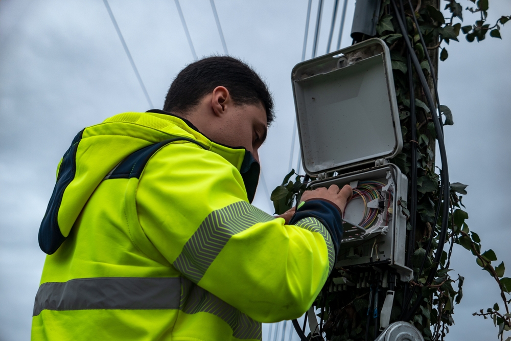Hombre arreglando señal en un poste de luz